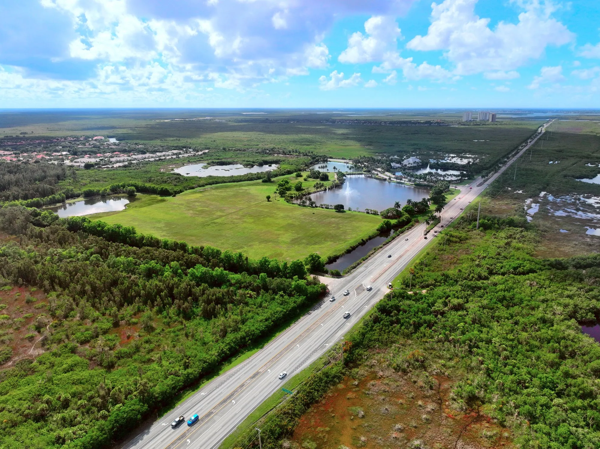 Aerial view from 394 ft over East Naples, with I-75, wetlands, and the Gulf coast on the horizon