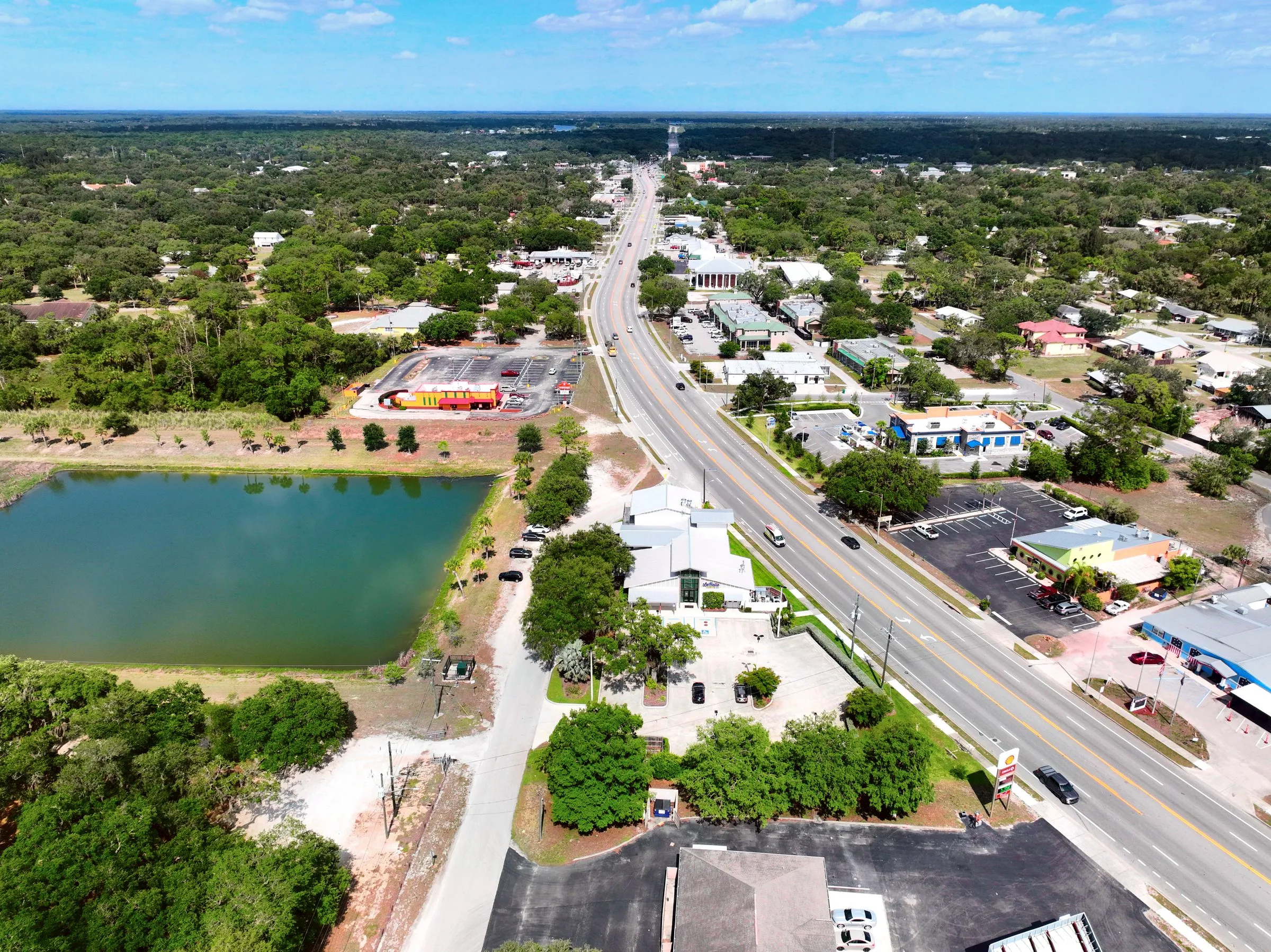 Aerial of Hickpochee Avenue (SR 80) through LaBelle with a retention pond and local businesses
