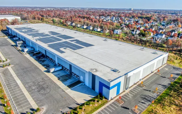 Aerial of a large distribution center with a solar-panel roof and loading docks