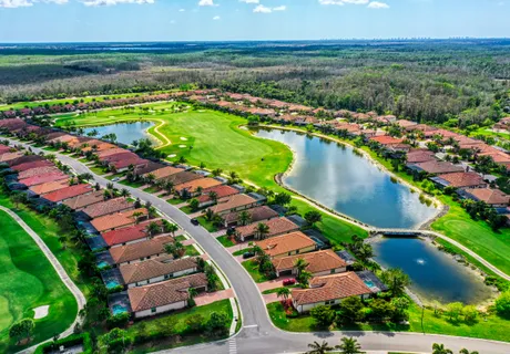 Aerial view of the Bonita National golf community, red-tile roofs and ponds along the fairways in Bonita Springs, Florida