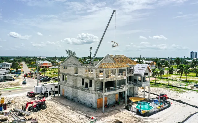 Aerial of a Fort Myers Beach spec-home rebuild with a crane and concrete shell
