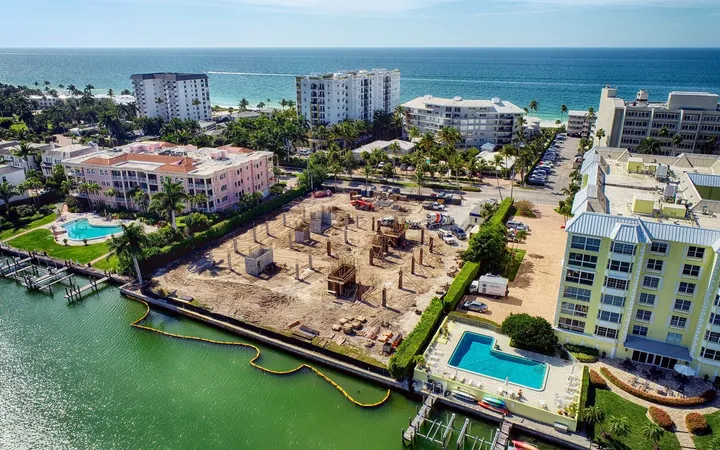 Aerial of a Naples waterfront foundation pour, ocean skyline behind