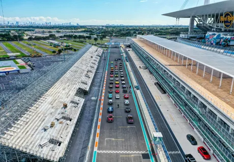 Aerial view of Hard Rock Stadium during the Miami Grand Prix, exotic cars staged on the pit straight with the Miami skyline behind