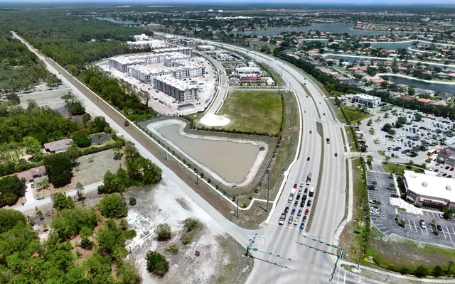 Aerial of a new commercial development taking shape along a road in Orangetree, Collier County